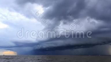 在海上、河口日落前，雨云在天空中蔓延，货船驶过。